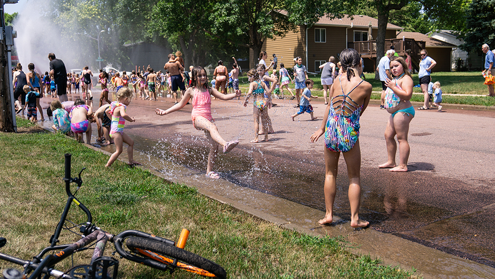 Children having fun playing in the puddles at the hydrant block party