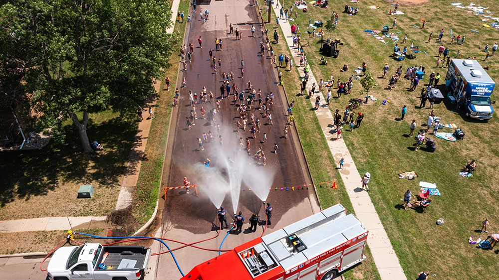 Birds eye view of the fire hoses spraying the hydrant party