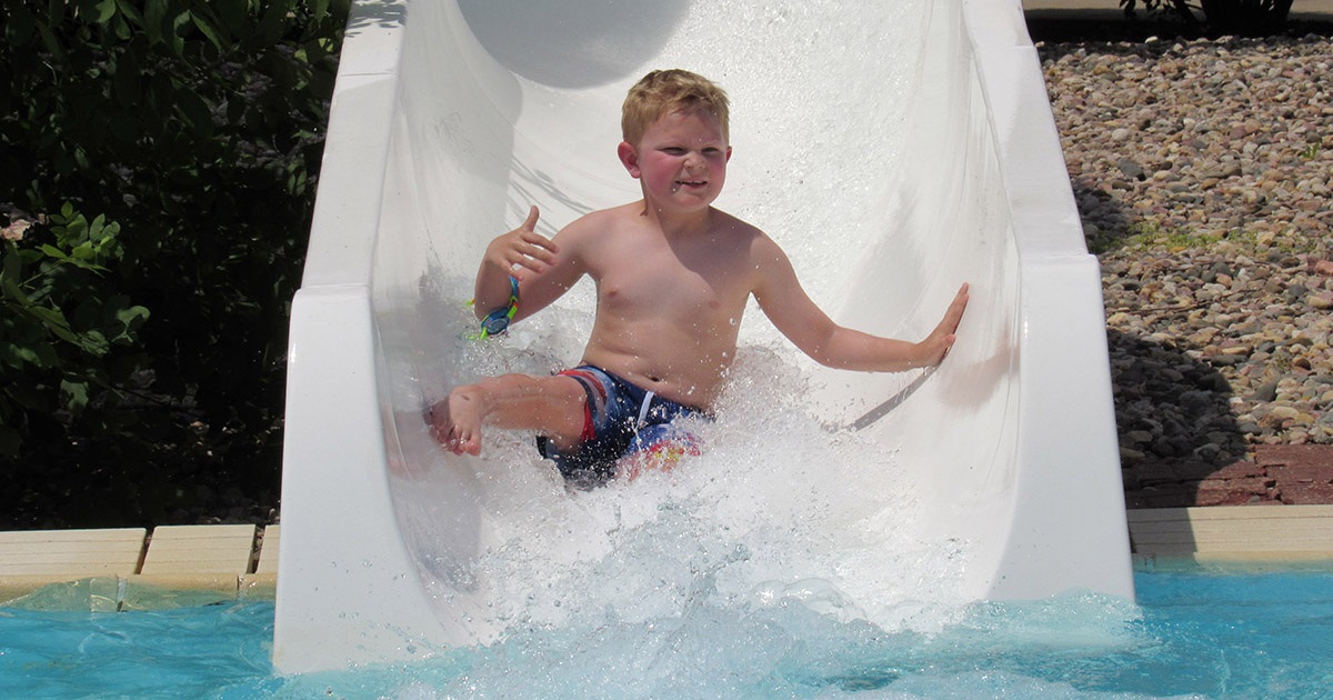 Little boy going down the water slide at terrace park pool